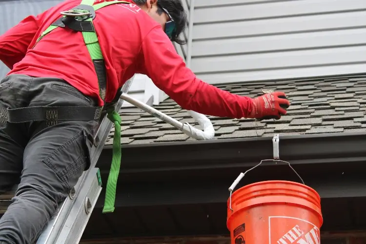 High Point Gutter specialist cleaning out gutter debris in Seattle